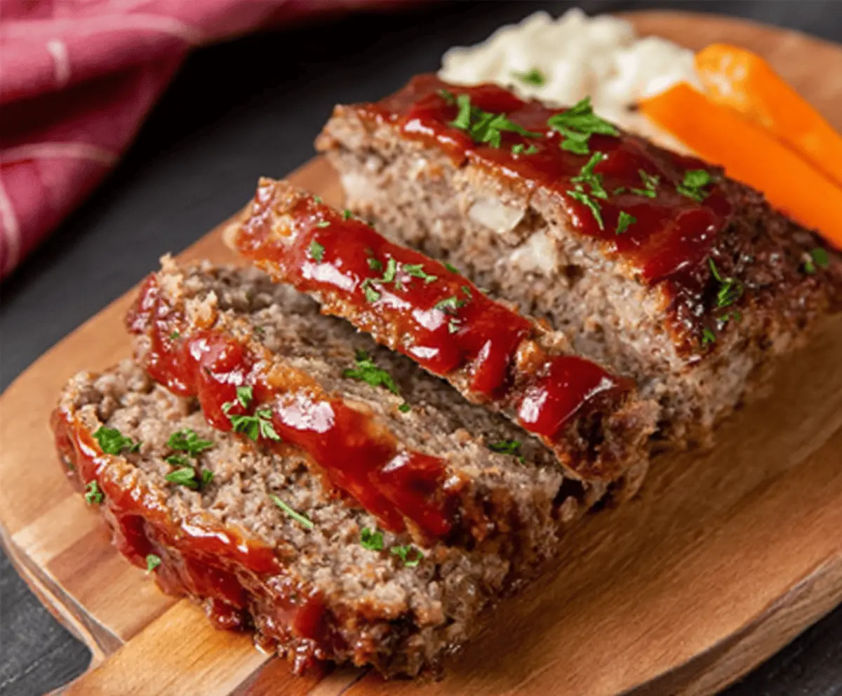 Delicious homemade Ranch Meatloaf garnished with fresh herbs on a white plate, perfect for a hearty family dinner