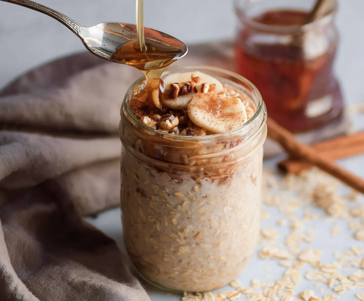 A jar of creamy Brown Sugar Cinnamon Overnight Oats topped with cinnamon and brown sugar for a delicious breakfast treat.