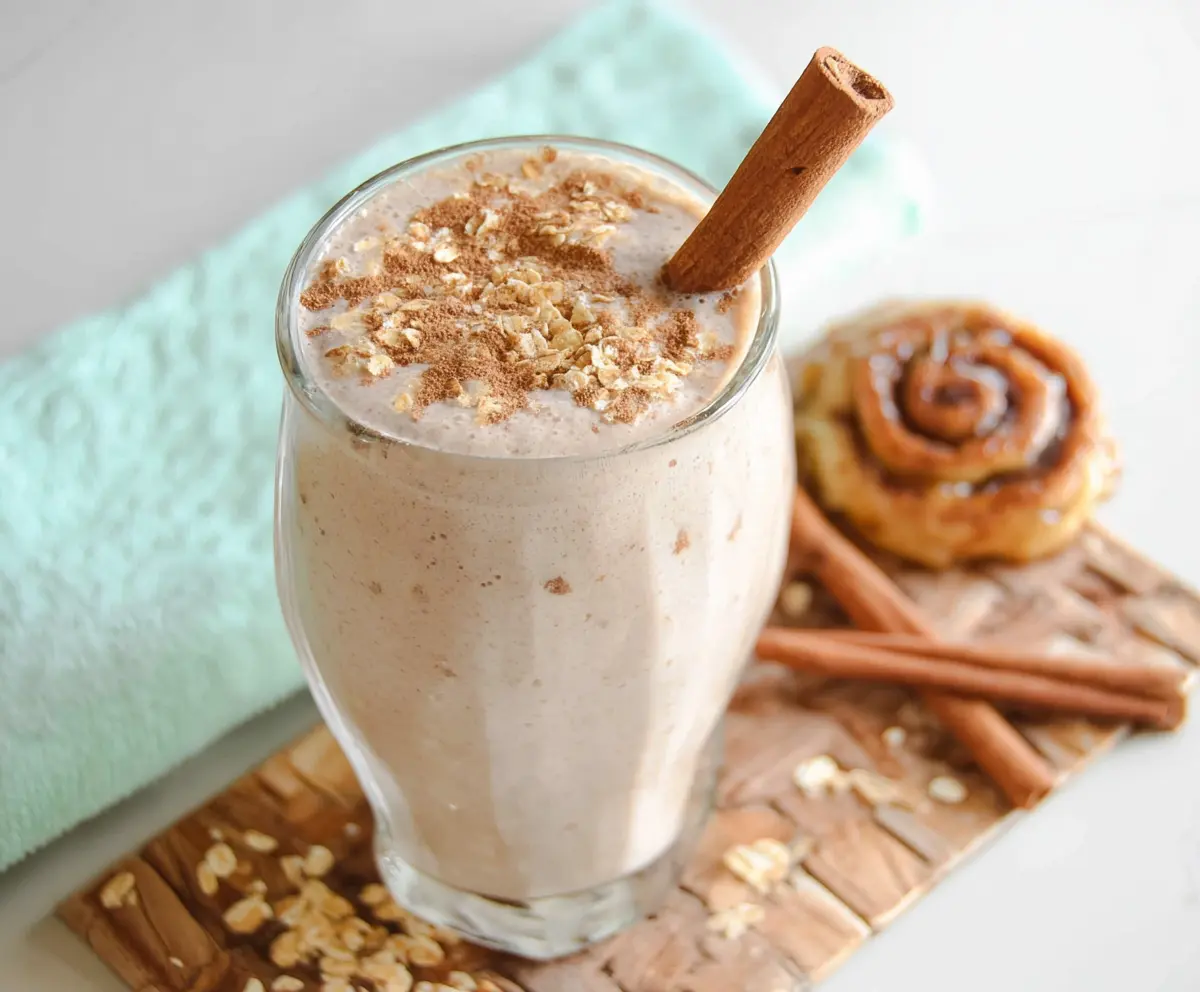 Delicious Cinnamon Roll Protein Shake in a glass topped with whipped cream and cinnamon, highlighting a healthy breakfast option.
