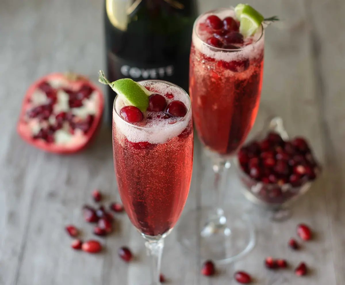 Refreshing cranberry prosecco pomegranate cocktail with fresh berries and sparkling bubbles in a elegant glass.