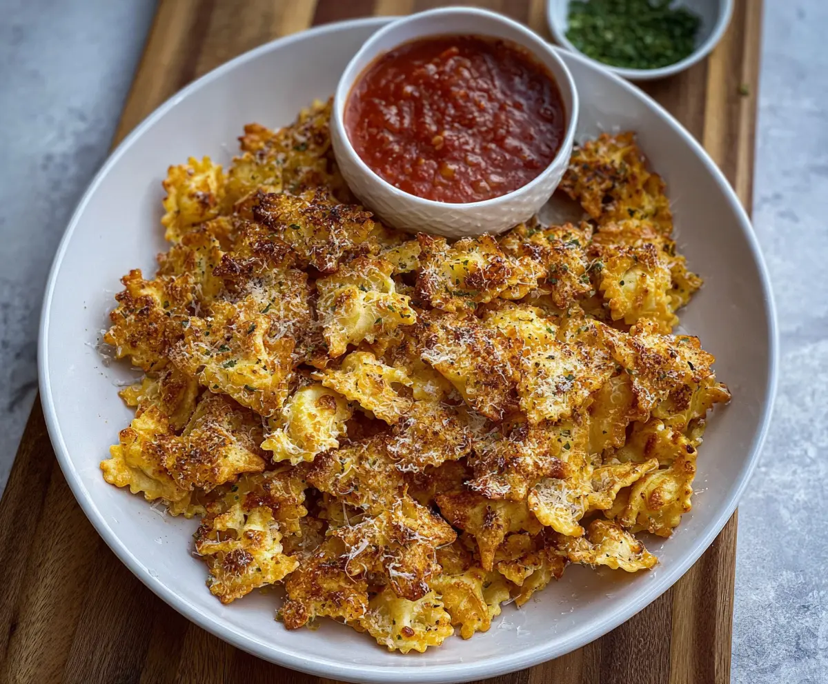 Oven baked cheesy pasta chips served on a plate with marinara sauce, perfect for snack time