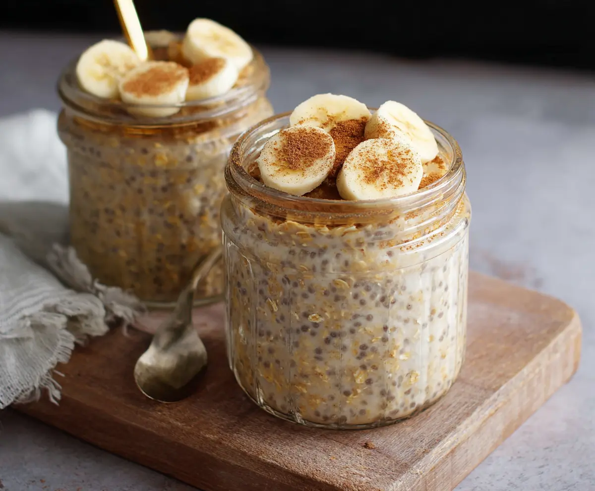 Creamy Banana Cinnamon Overnight Oats in a glass jar, topped with banana slices and cinnamon for a healthy breakfast.