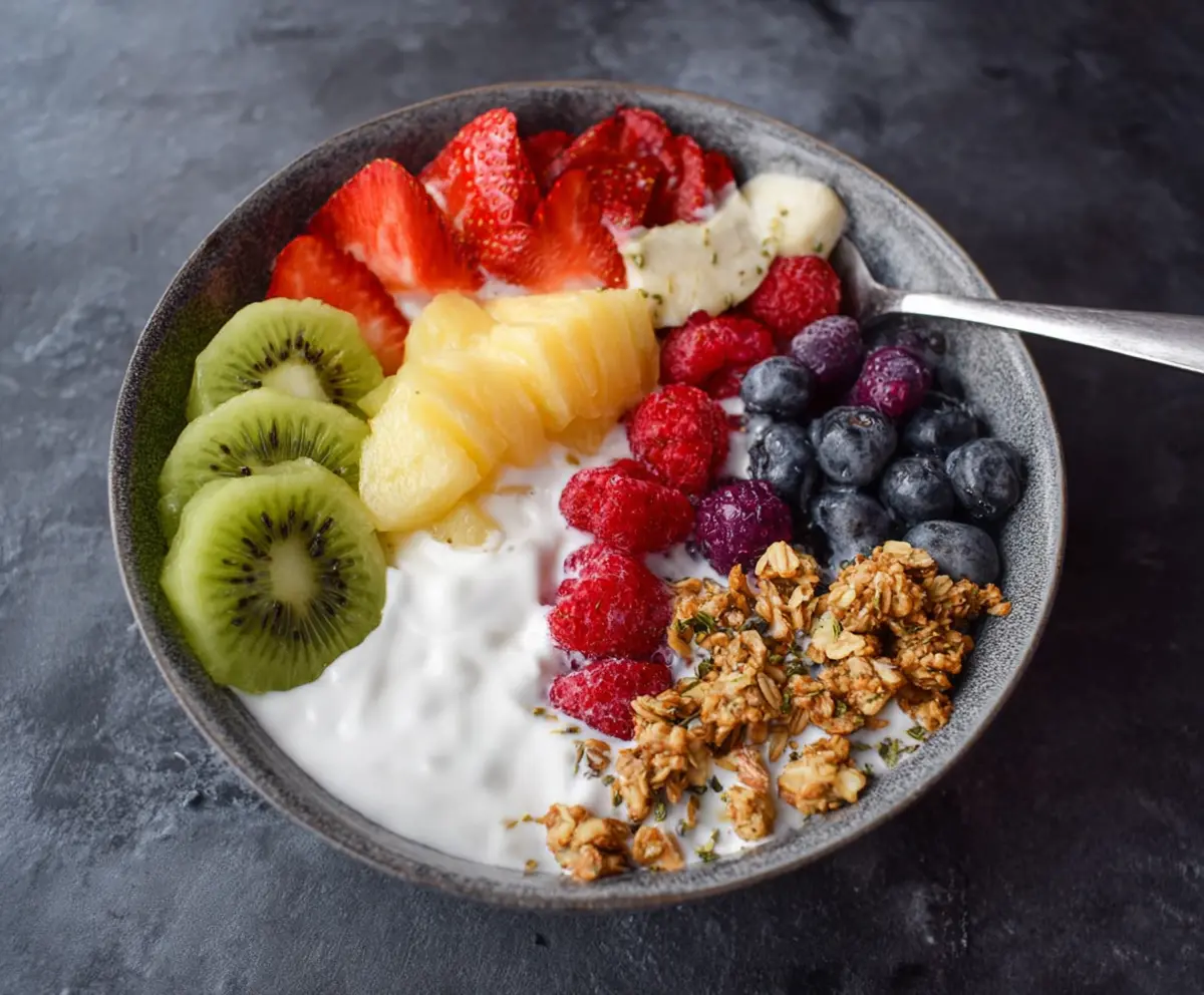 Colorful fruits and creamy yogurt in a nutritious breakfast bowl, perfect for a healthy start to the day.