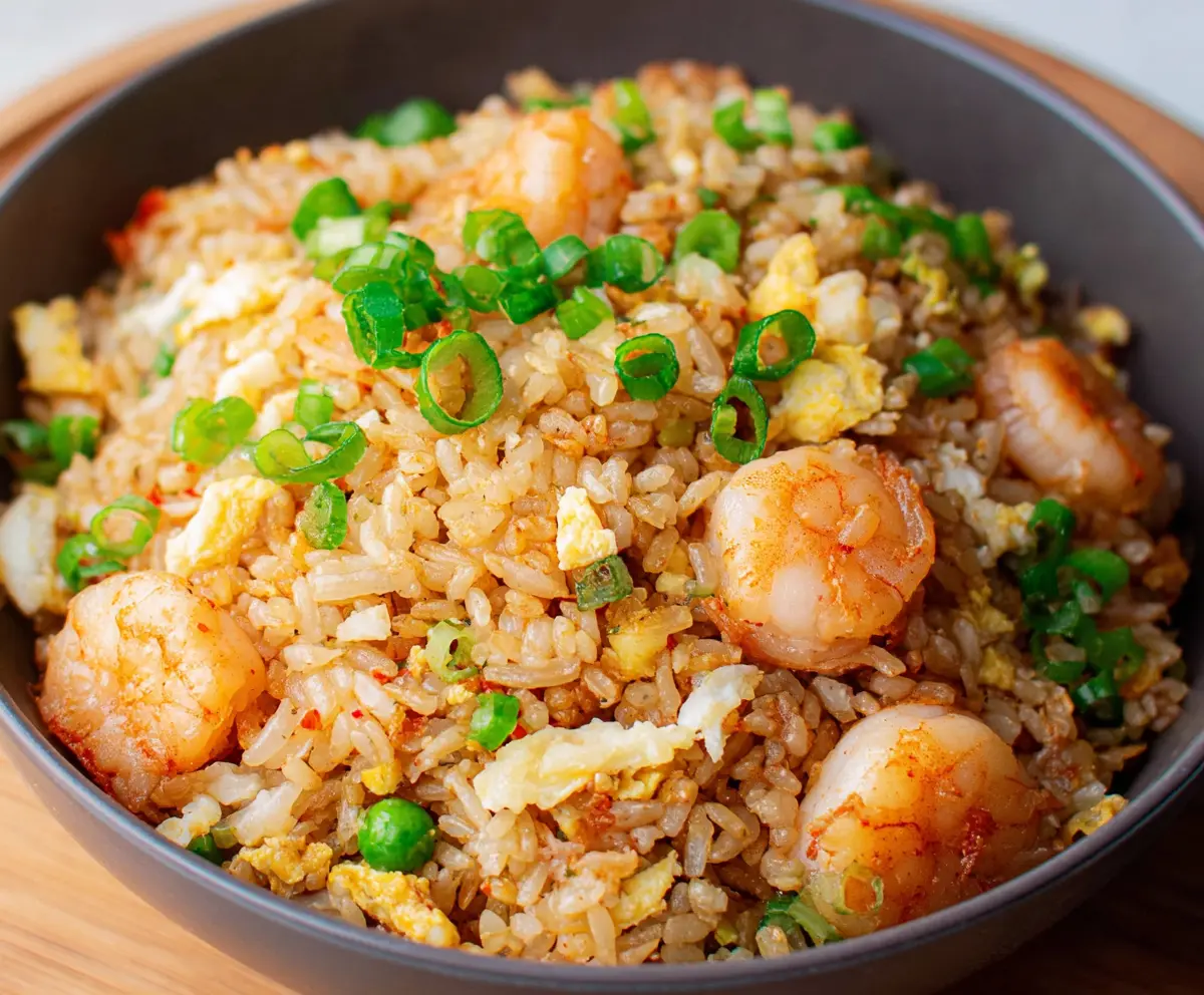 Delicious shrimp garlic fried rice served on a plate, garnished with fresh herbs.