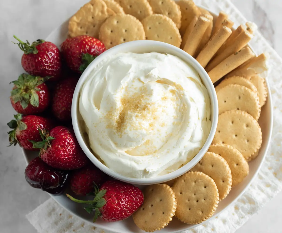 Creamy 3 Ingredient Cheesecake Dip with graham crackers and fresh strawberries in a bowl.