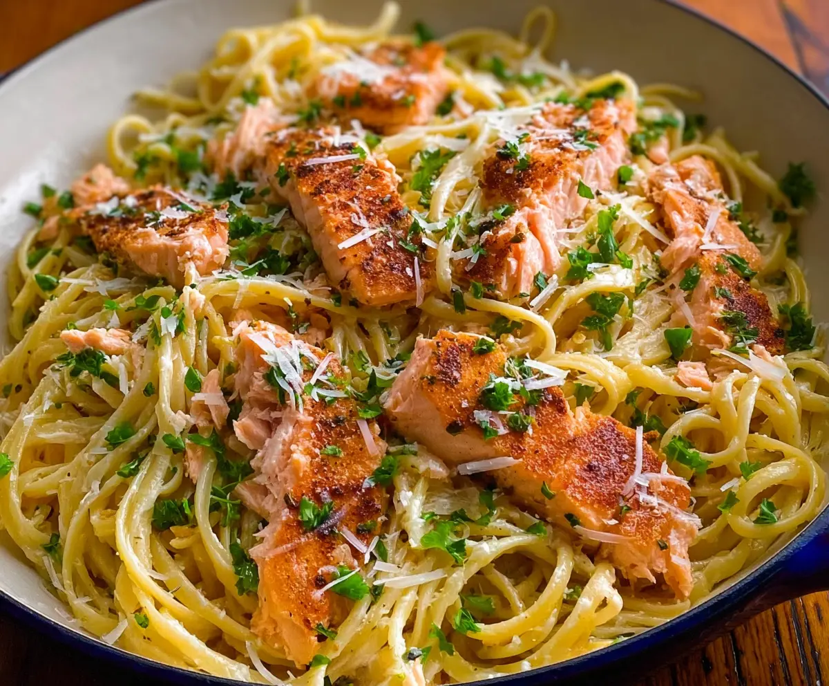 Delicious Lemon Butter Salmon Pasta served on a white plate with fresh herbs
