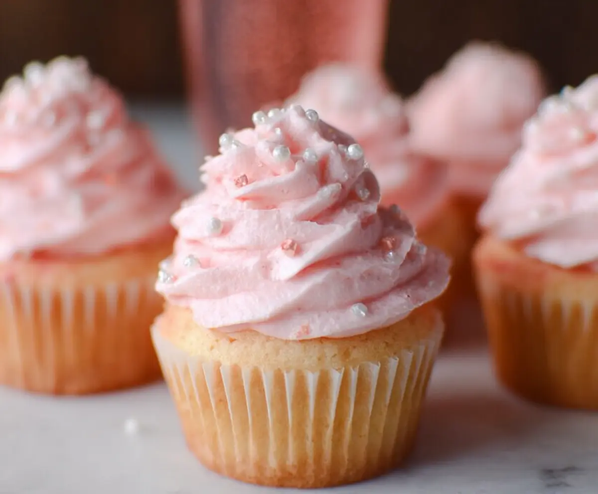 Delicious Pink Champagne Cupcakes with pink icing and sprinkles, perfect for celebrations.