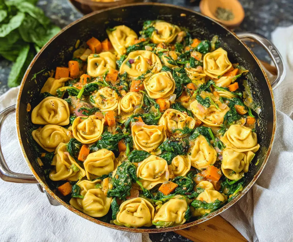 Delicious skillet tortellini with sweet potatoes and fresh spinach, a hearty and colorful vegetarian dinner