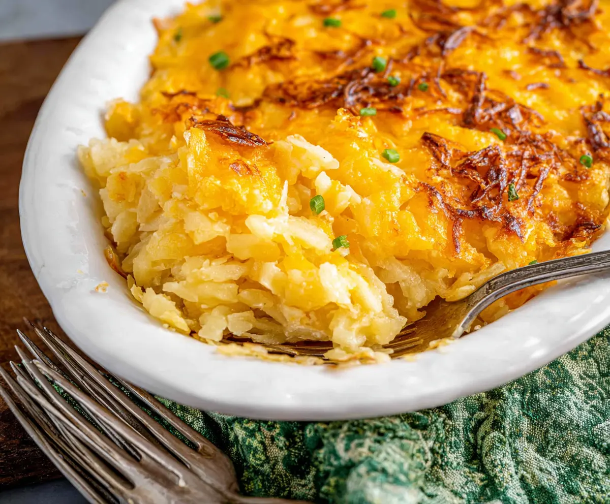 Delicious cheesy hashbrown potato casserole topped with golden melted cheese and crispy edges.