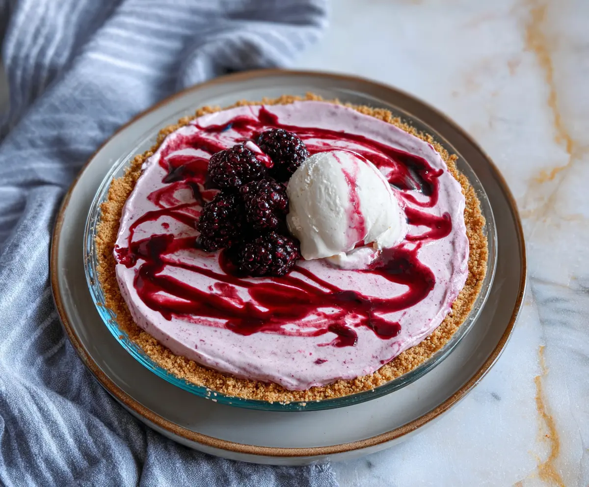 Delicious Blackberry Ice Cream Pie topped with fresh blackberries and mint for a cool summer dessert.